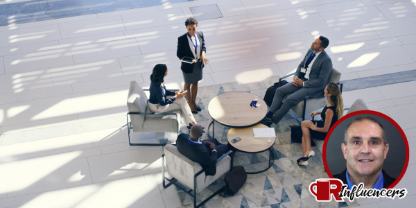 Professionals holding a meeting in a circle, John Kenney’s headshot overlayed